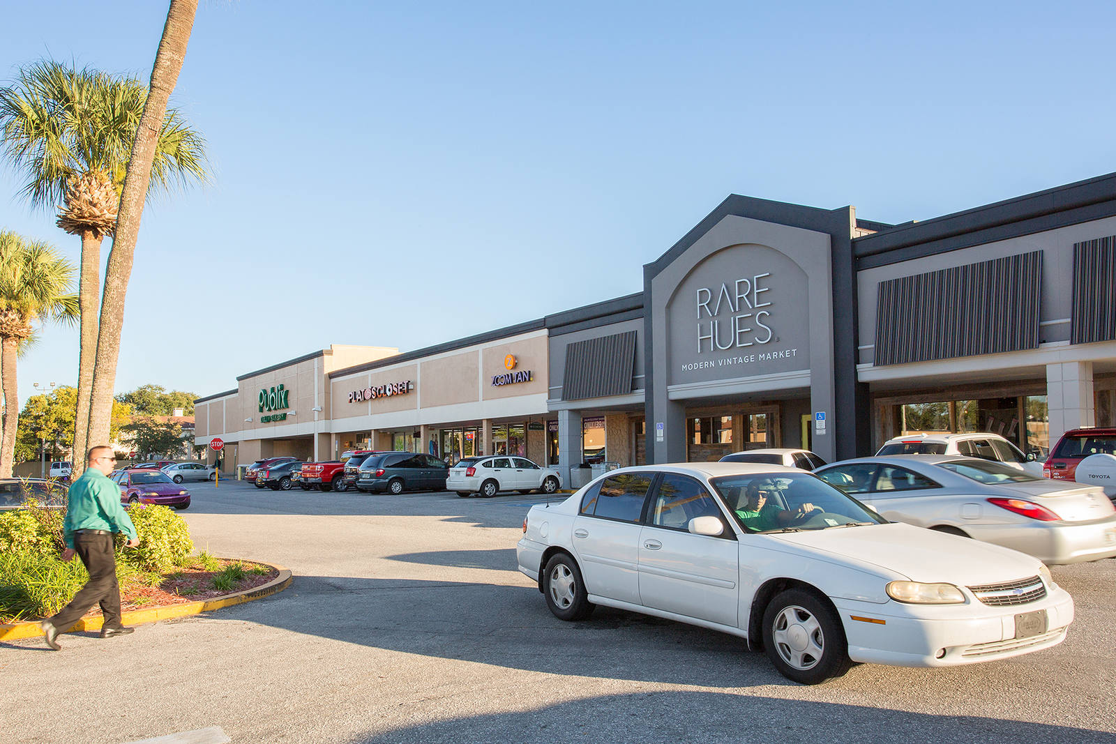Pedestrian, cars and palm trees in front of Rare Hues vintage Market in Tampa, FL.