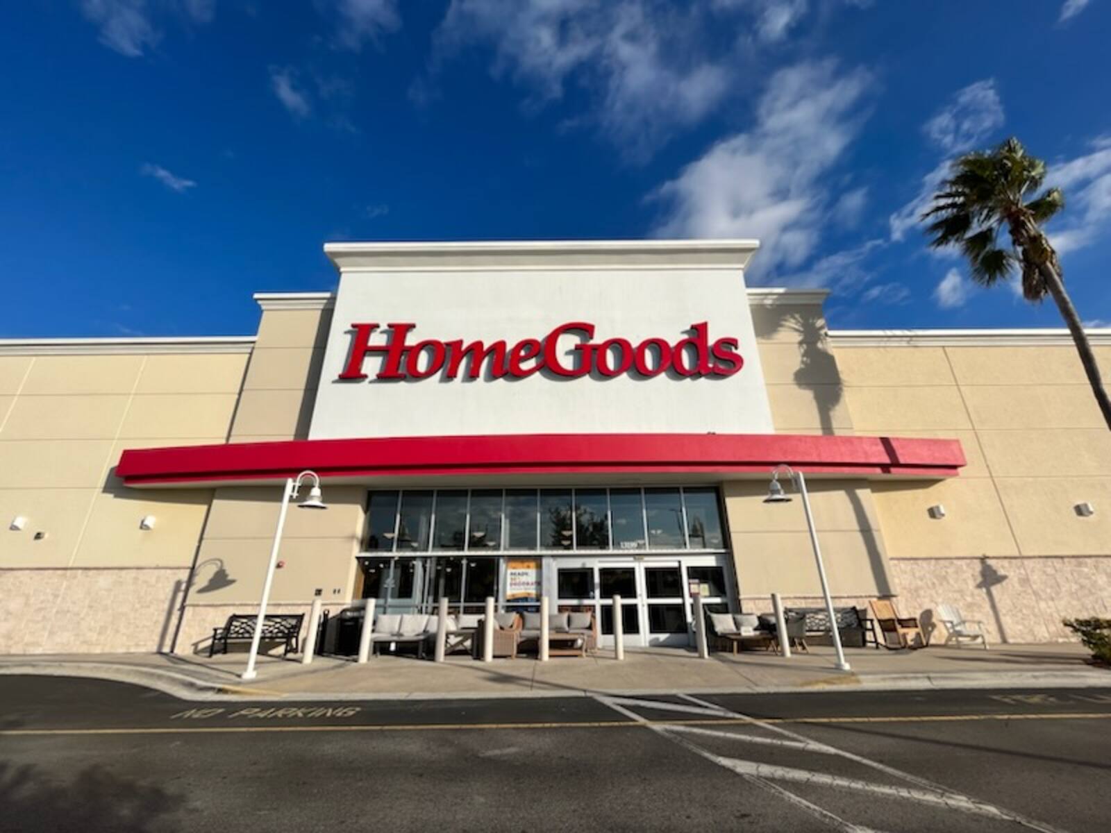 HomeGoods storefront with navy sky and palm tree on the right.