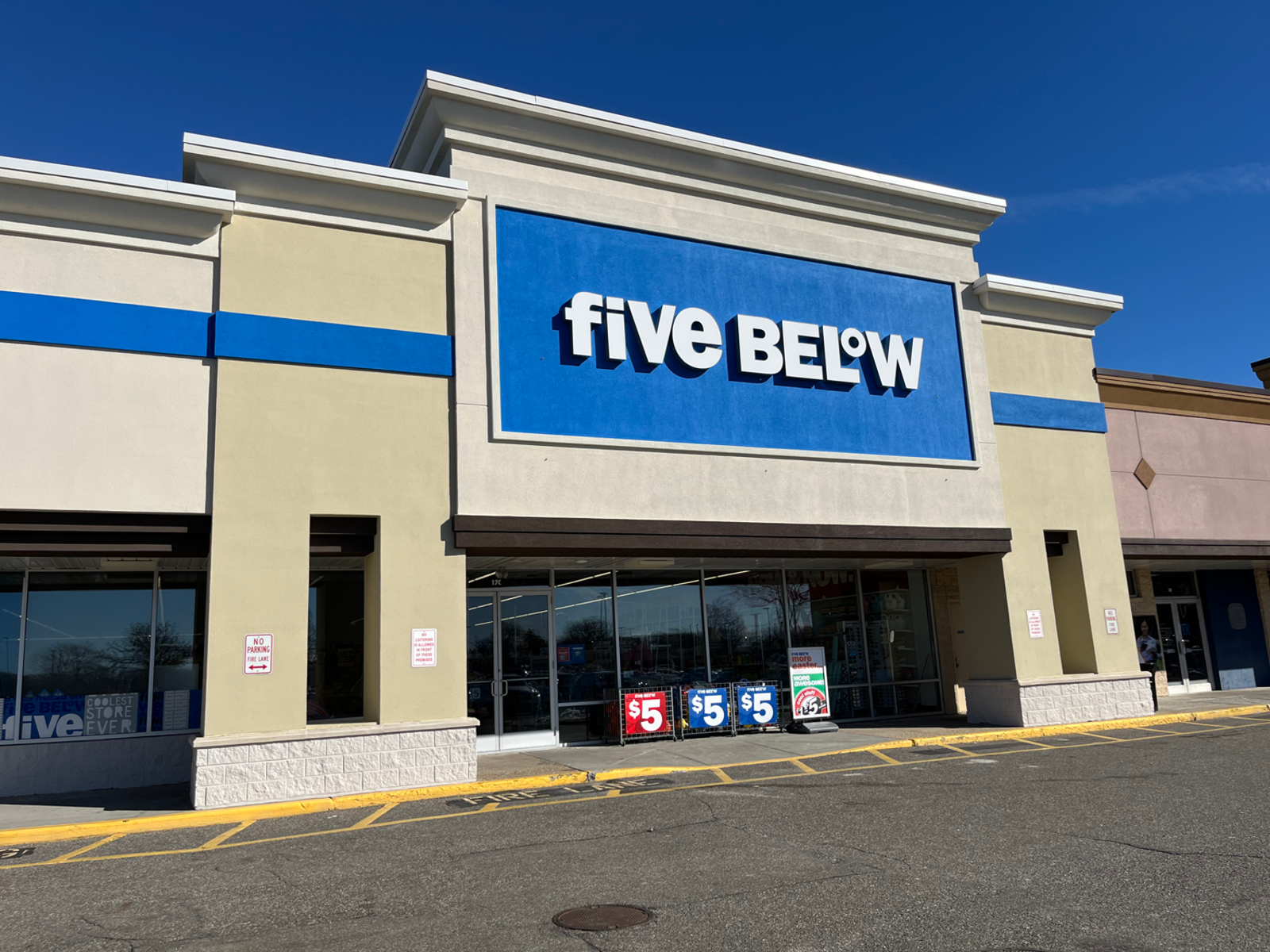 Façade of Five Below with blue sky behind it.