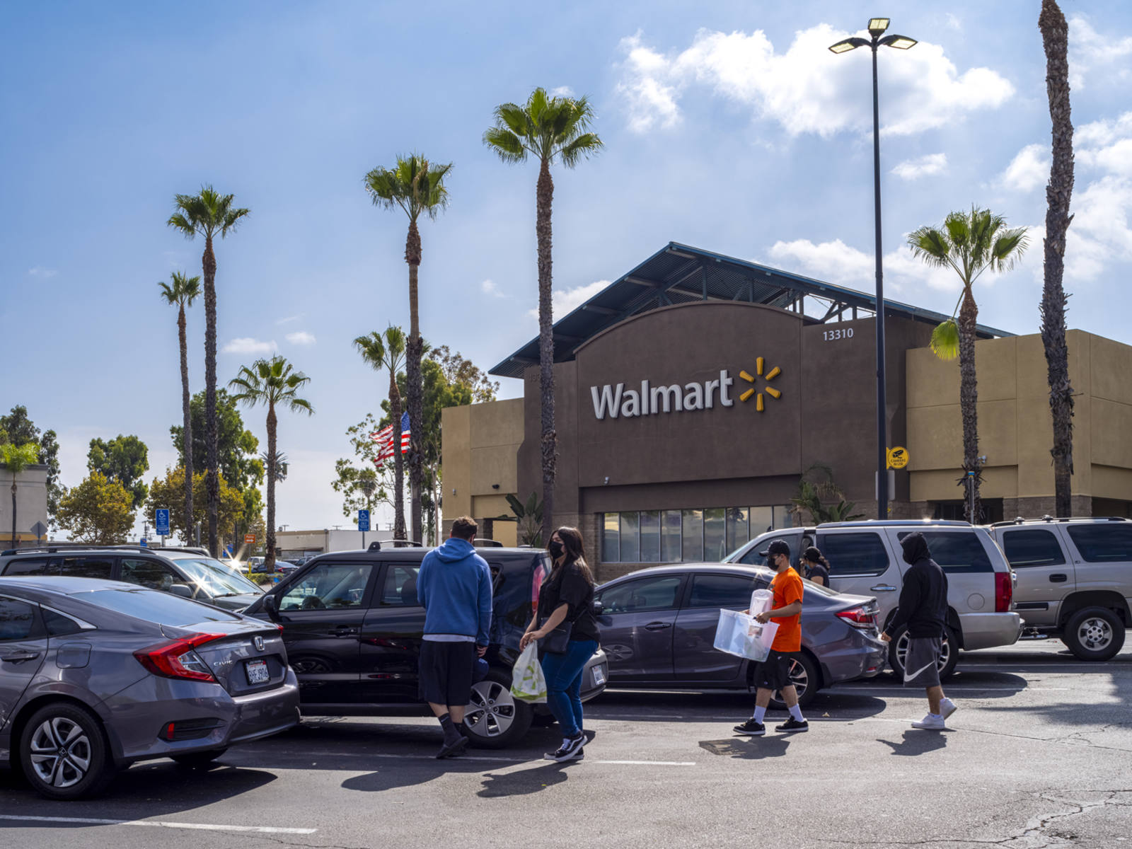 Customers putting bags in car in parking lot at Walmart in Santa Fe Springs, CA.