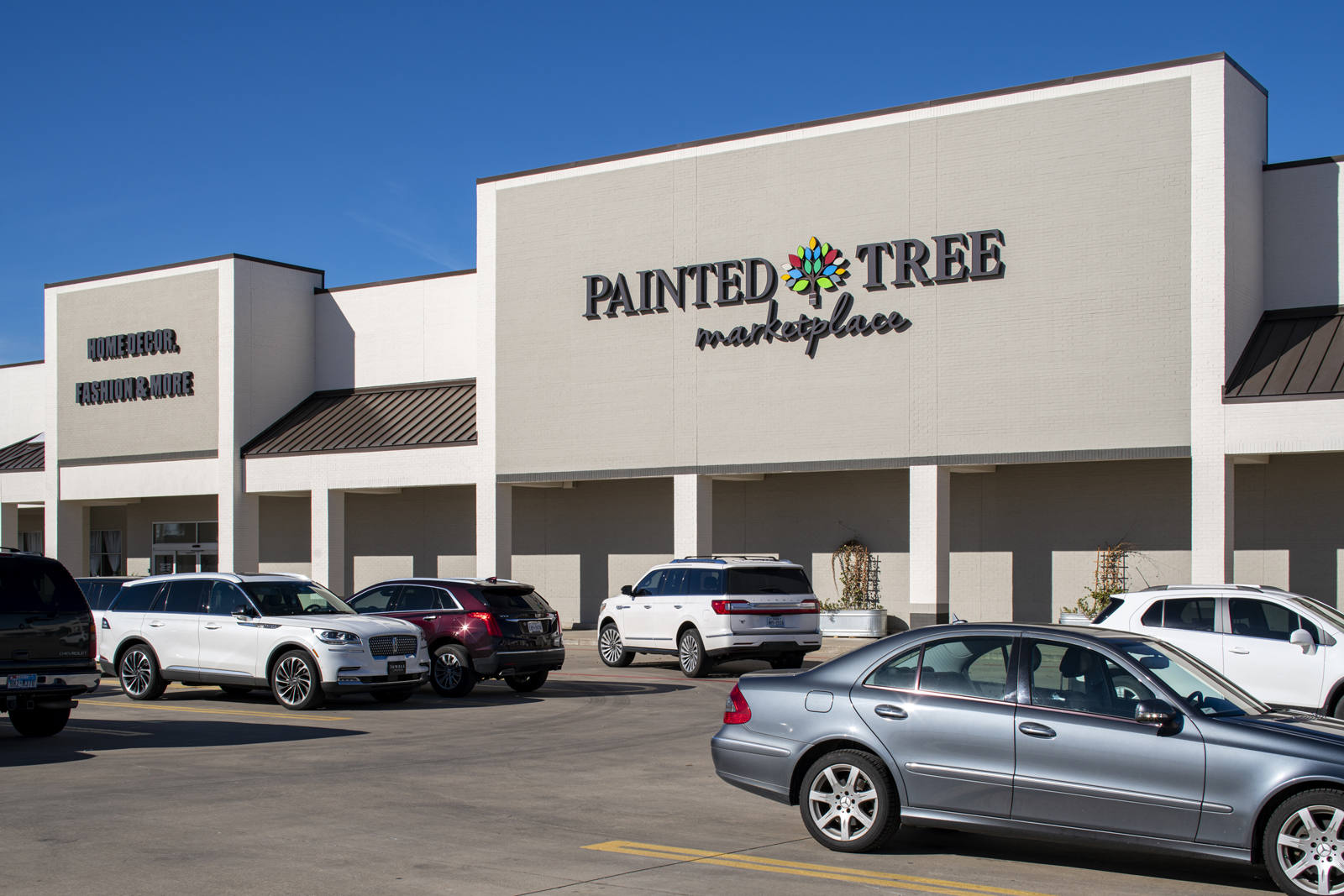 Painted Tree Marketplace with busy parking lot at Highland Village Town Center.