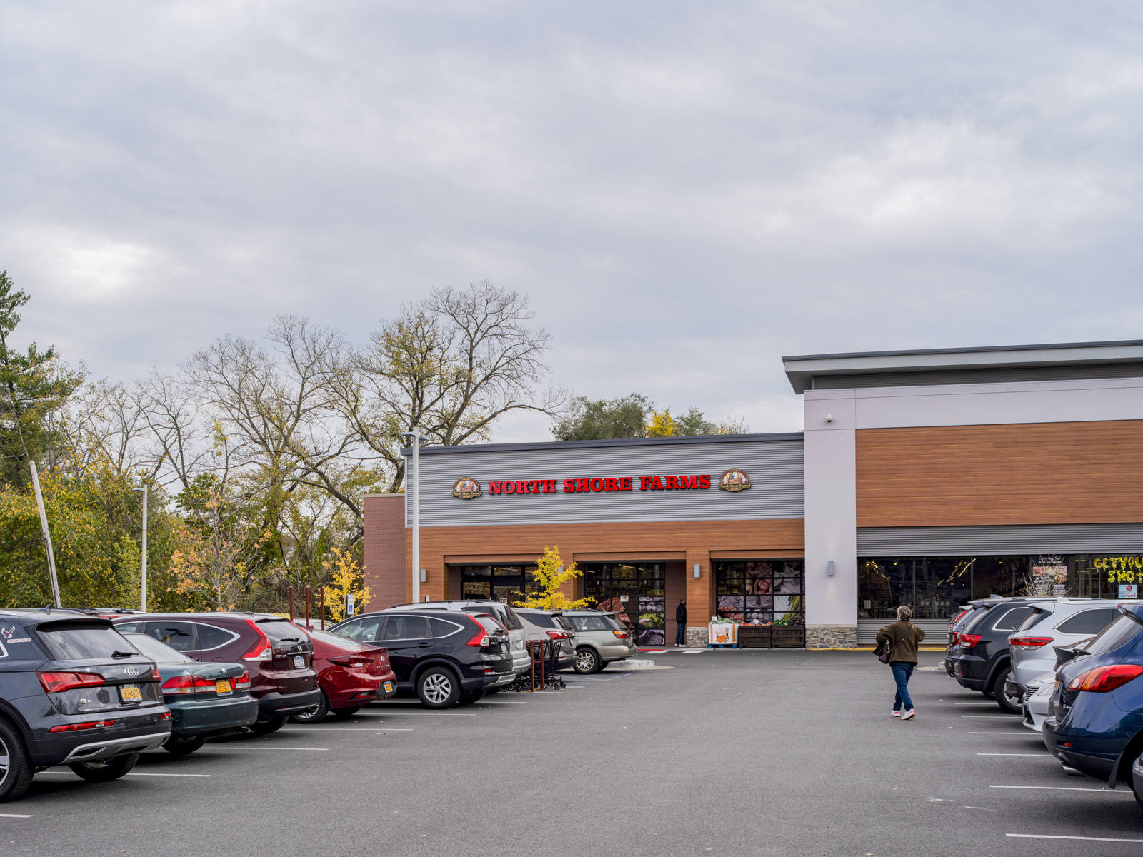 Customer walking down rows of cars in parking lot at North Shore Farms.