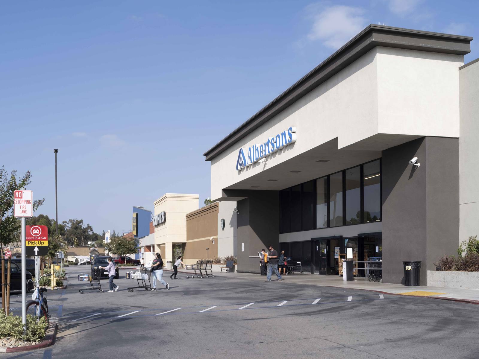 Albertson's supermarket with customers pushing carts in crosswalk at Montebello Plaza.