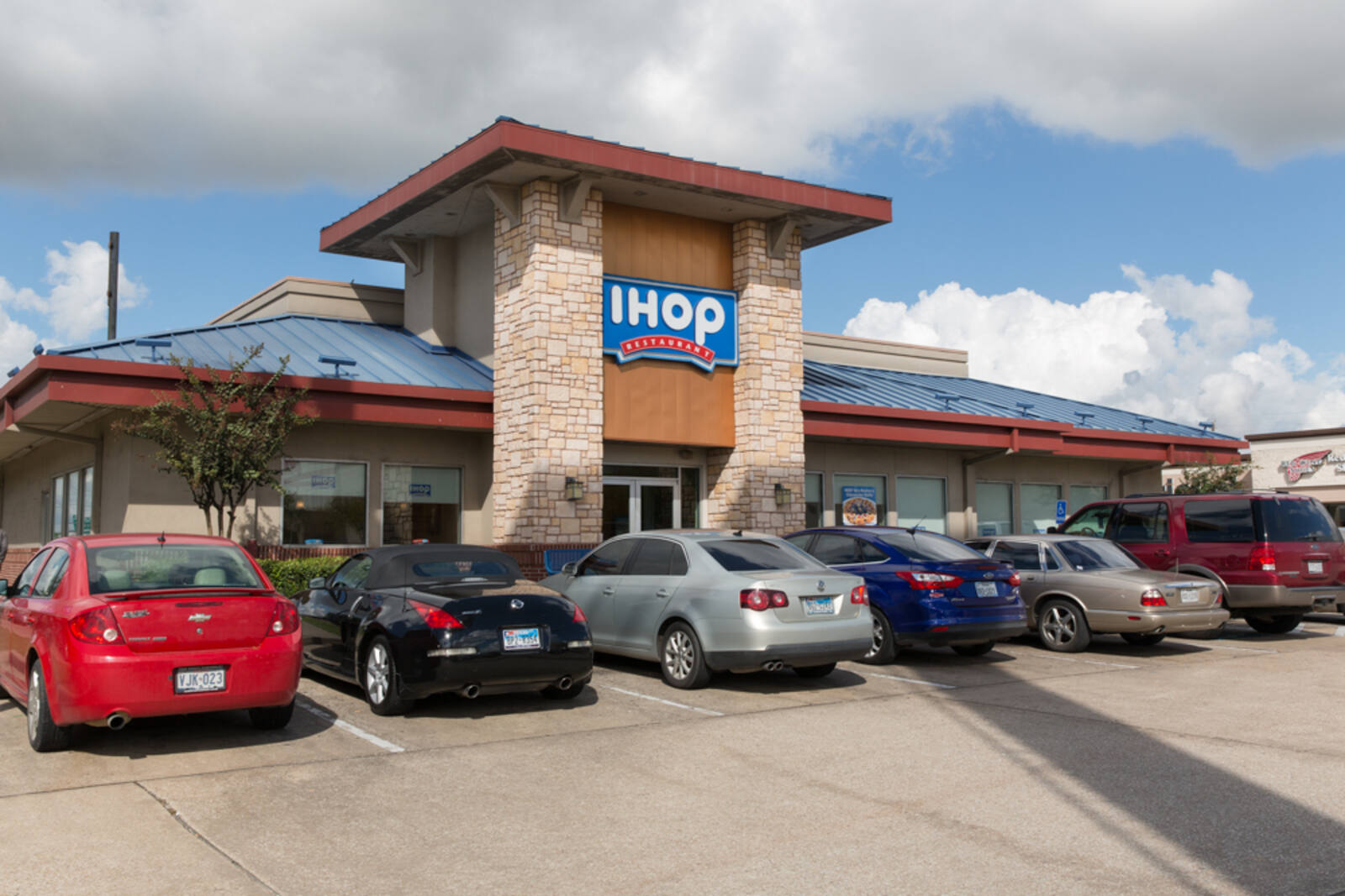 Busy parking lot in front of iHop on a cloudy day.
