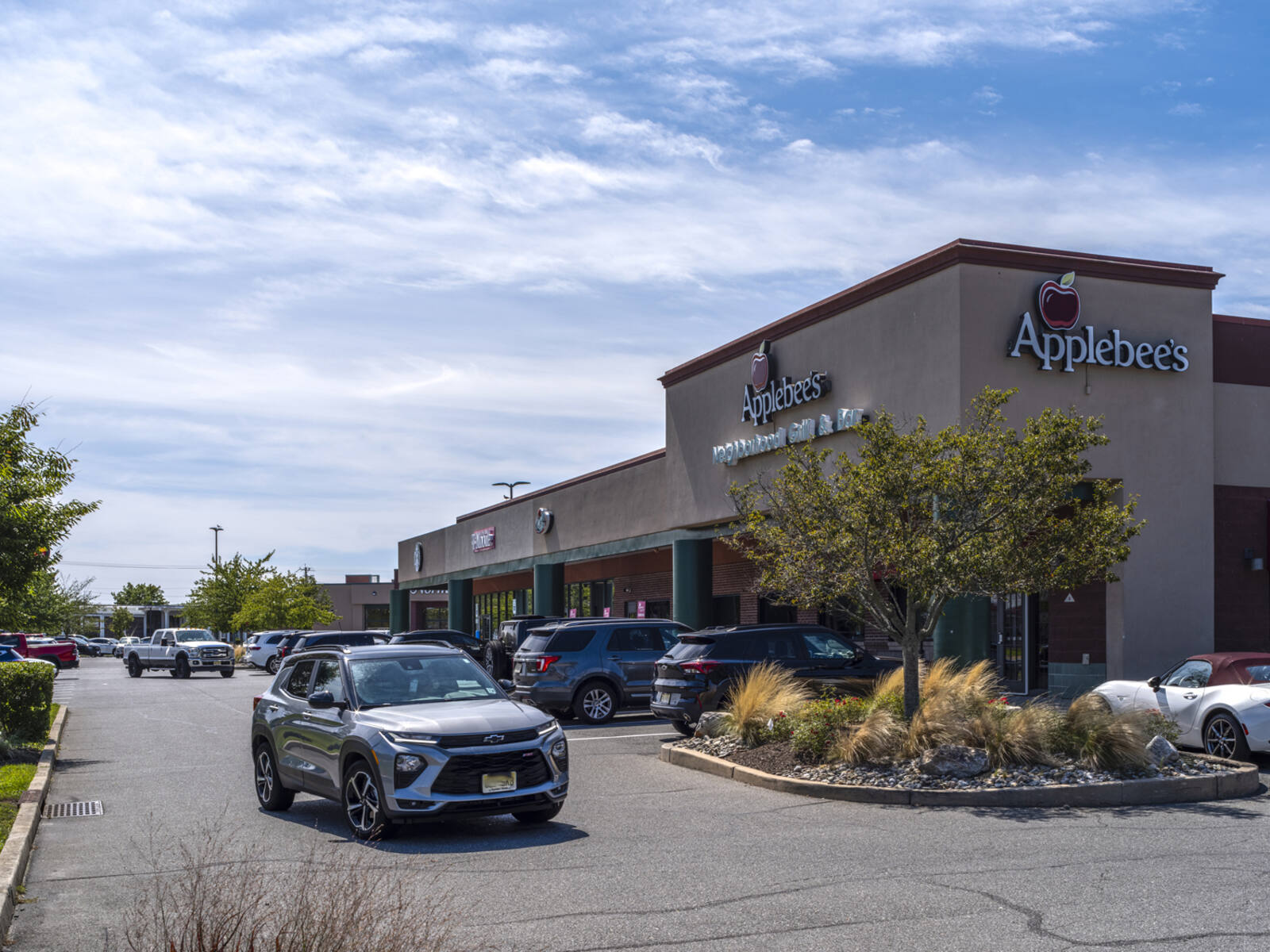 Busy parking lot and exit road at Applebee's restaurant. 