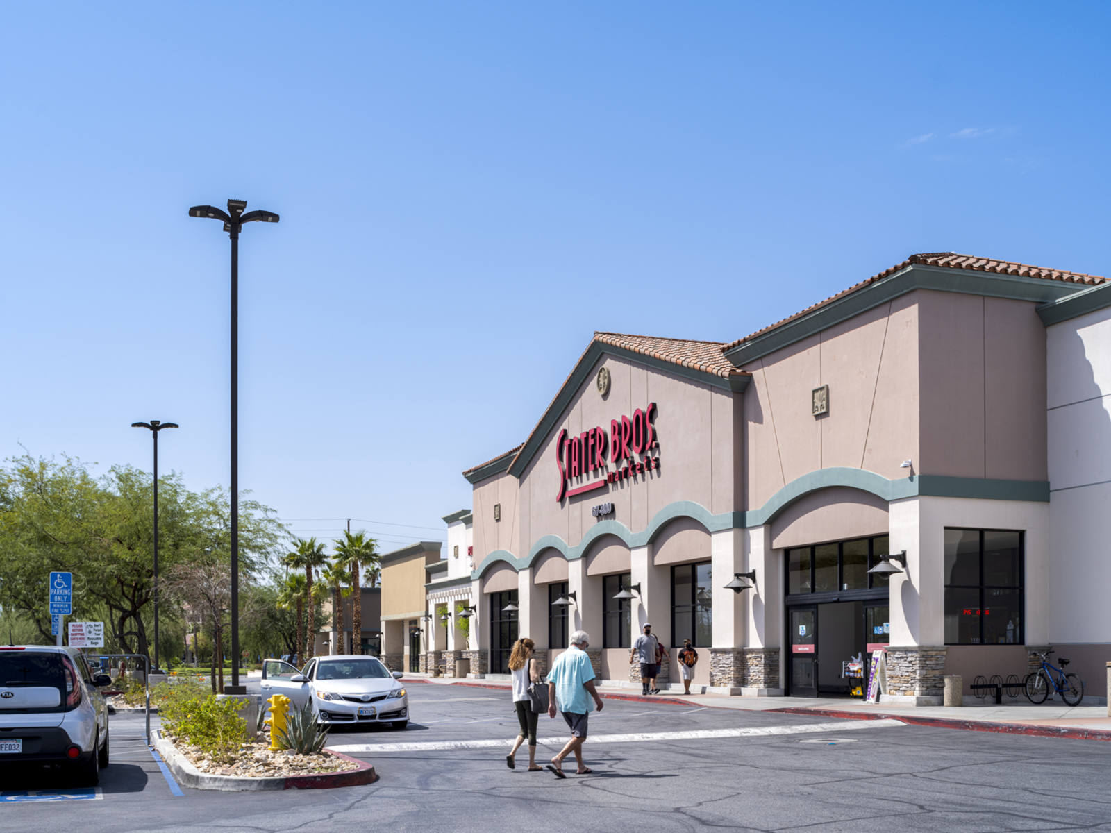 Two people walking towards entrance of Stater Bros. at Plaza Rio Vista shopping center