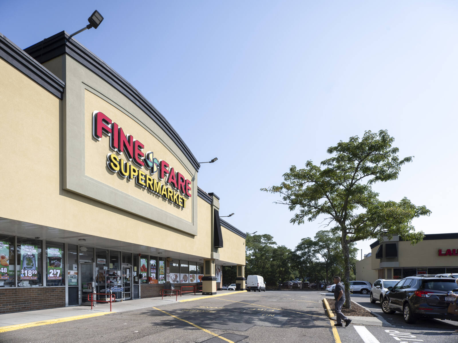 Fine Fare Supermarket grocer with parking lot and small tree in front.