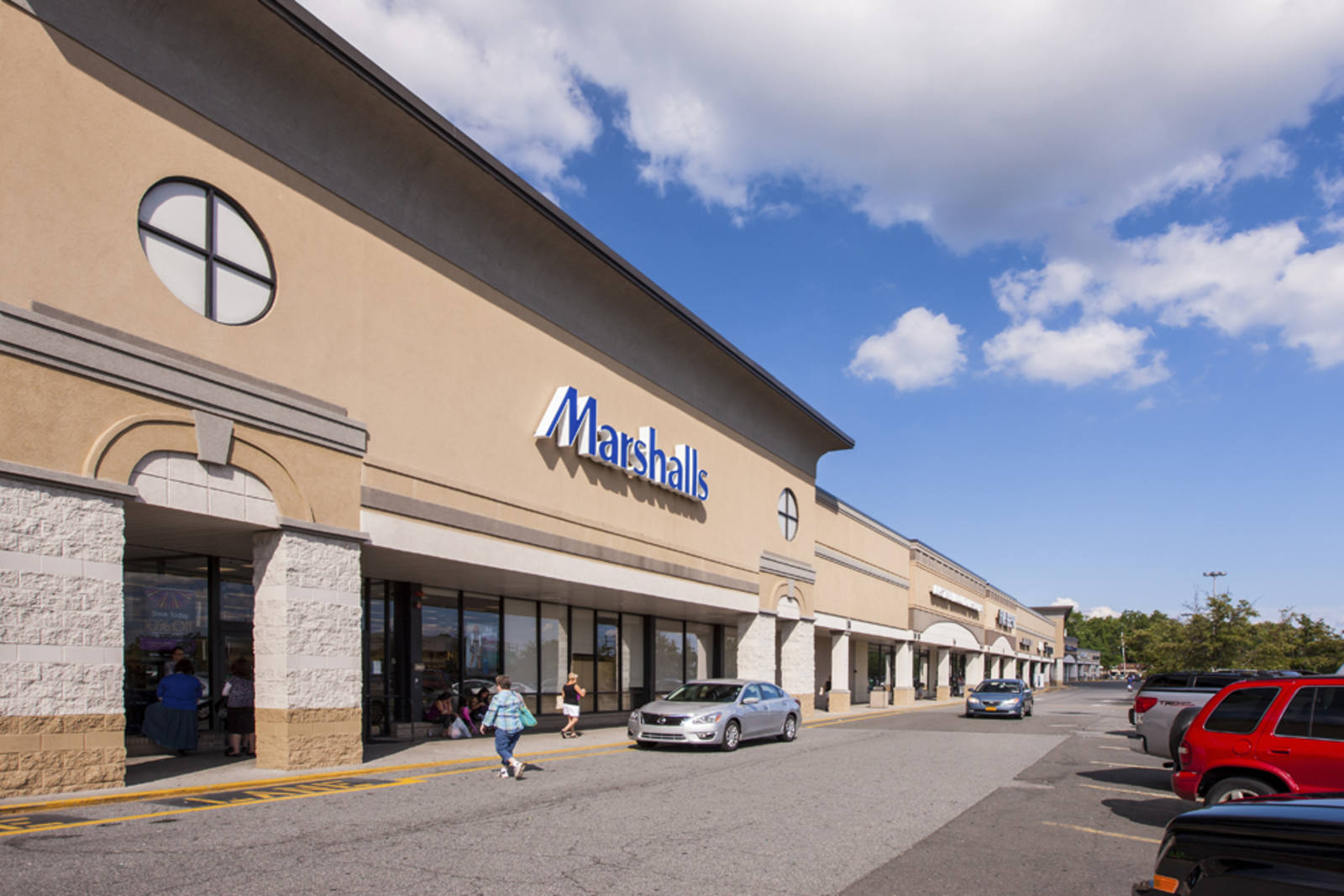 Person walking in front of tan car towards entrance of Marshalls at Rockland Plaza shopping center