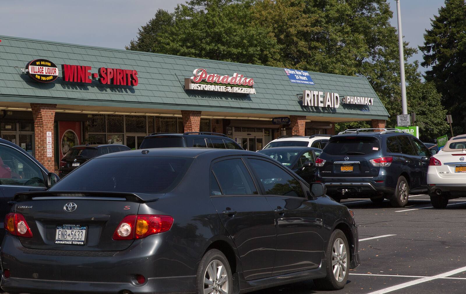 Filled parking lot in front of small shops at Rockville Centre