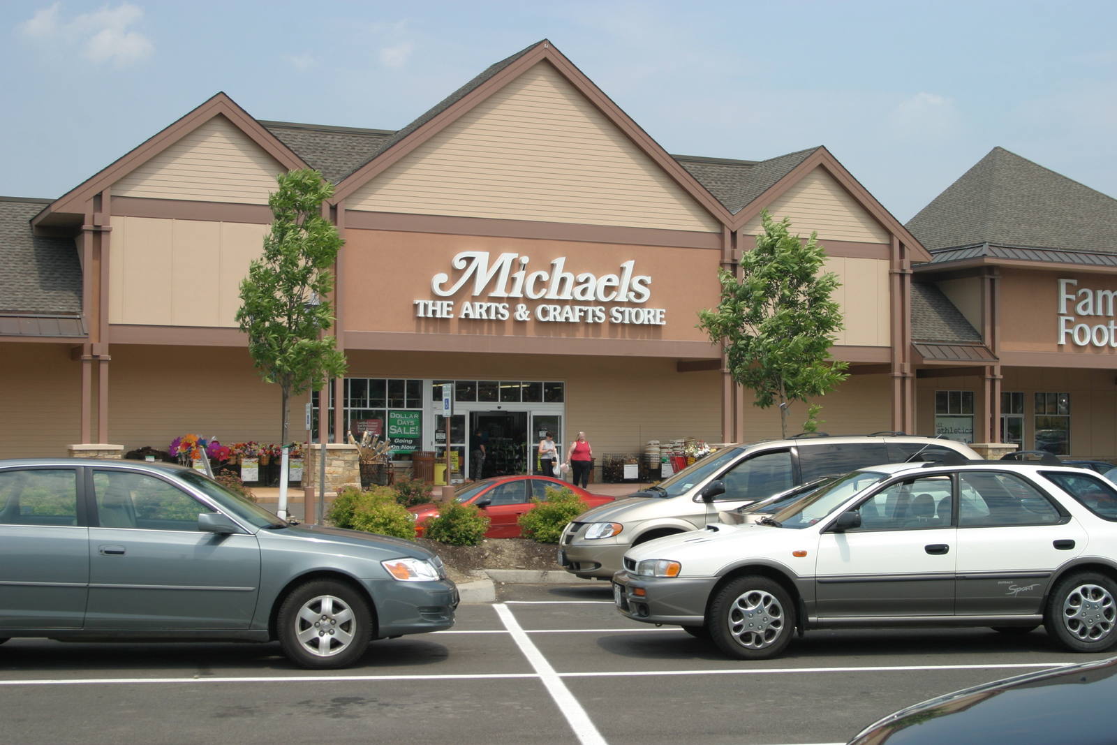 Full parking lot in front of Michaels with two trees at either side of the store's entrance