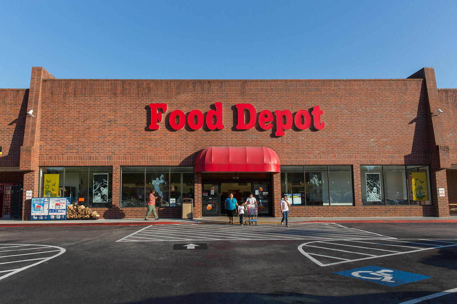 People walking out of Food Depot at Sweetwater Village shopping center