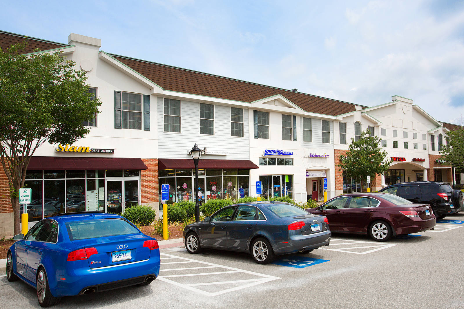 Cars parked lining the entrance of small shots at The Shoppes at Fox Run