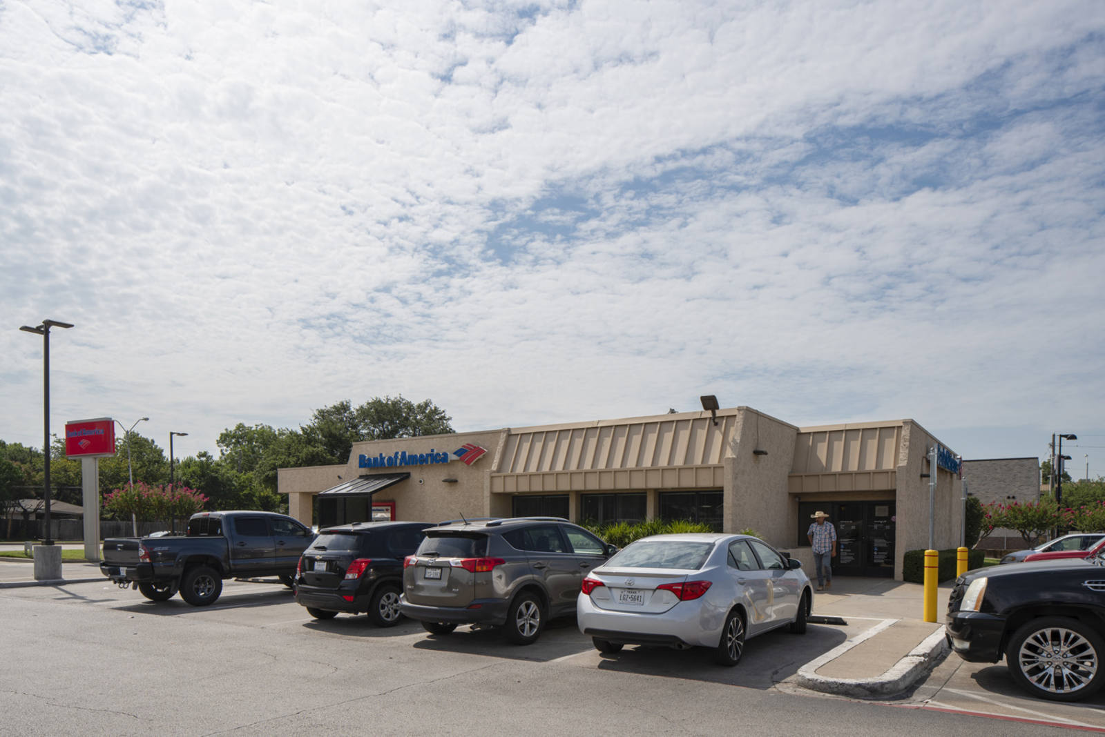 Cars parked in line at the entrance of Bank of America at Webb Royal Plaza Shopping Center